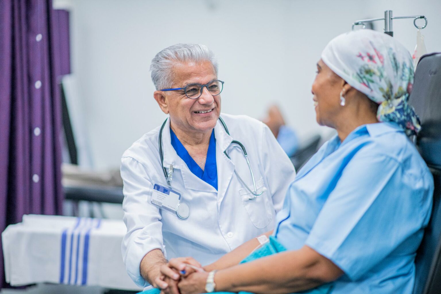Photo of a doctor reassuring his patient during treatment in the Sonobird clinical trial for glioblastoma.